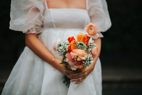 A bride holding a beautiful spring bouquet of colourful flowers.