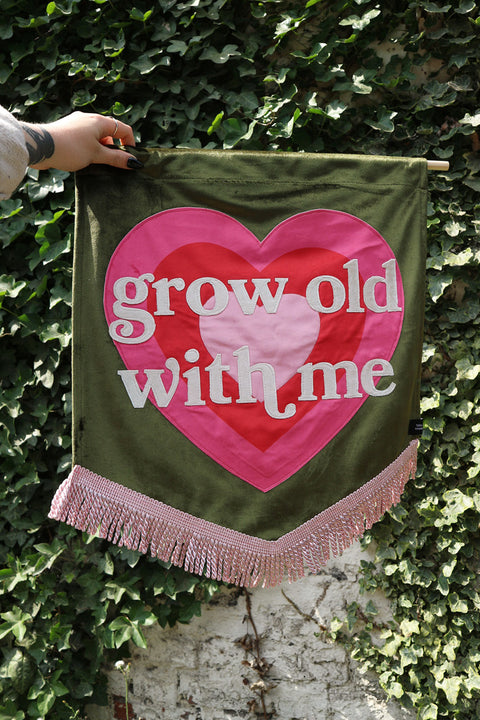 Olive wedding sign with Y2K pink heart & "grow old with me" text in white on ivy background.