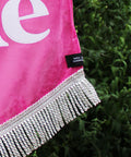 Close up of velvet wedding banner in pink with "you and me" white text and silver fringing