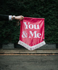 Velvet wedding banner in pink with "you and me" text, held by groom.