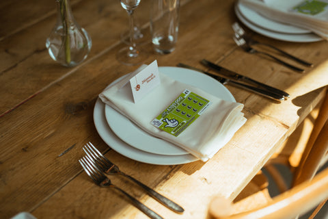 Wedding venue place setting with lottery scratch card on plate.