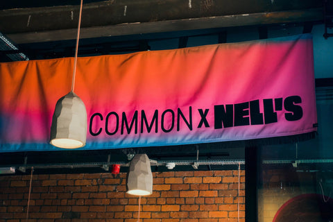 Interior horizontal banners with "Common x Nell's" text, showing detail of colours and lettering