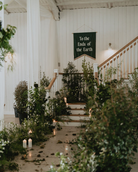 Velvet wedding banner in green with "to the ends of the earth" text in wedding venue