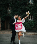 Couple holding velvet wedding banner in pink with "you and me" text