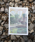 A risograph print of a water feature in Castle Ashby grounds, placed on a stony floor.