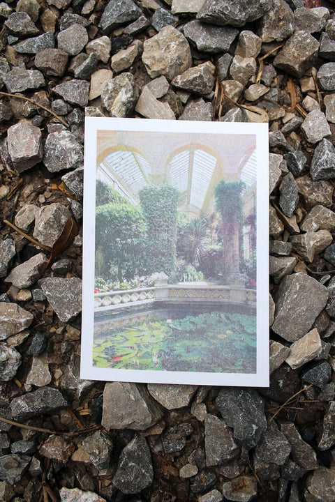 A risograph print of a water feature in Castle Ashby grounds, placed on a stony floor.
