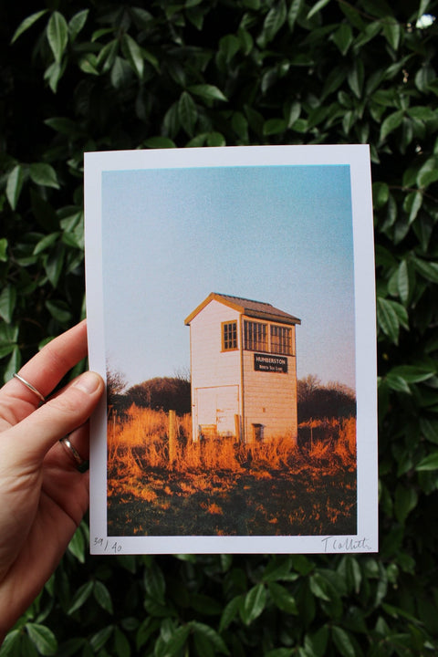 Hand holding A5 risograph print of Cleethorpes North Sea Lane station hut.