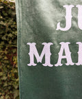 Super close up of velvet wedding banner in green showing stitching detail.