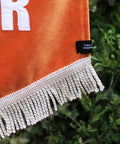 Velvet wedding banner in orange with details of white fringing.