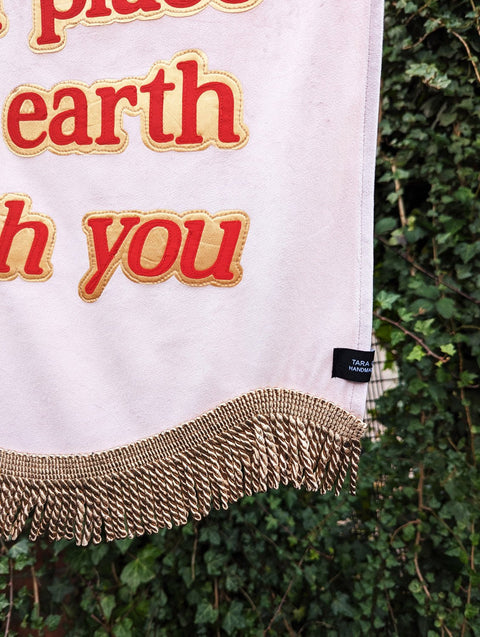 Baby pink velvet banner with close up of red "heaven is a place on earth with you" text outlined in shiny gold.
