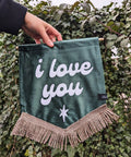 Ivy leaf backdrop with green velvet banner, ivory gold fringing, and "i love you" text.