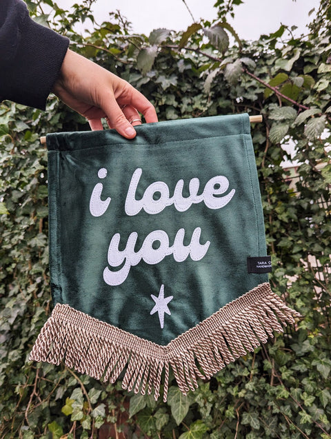 Ivy leaf backdrop with green velvet banner, ivory gold fringing, and "i love you" text.