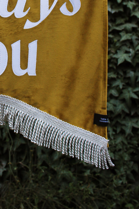 Close up of velvet wedding banner in gold with silver fringing
