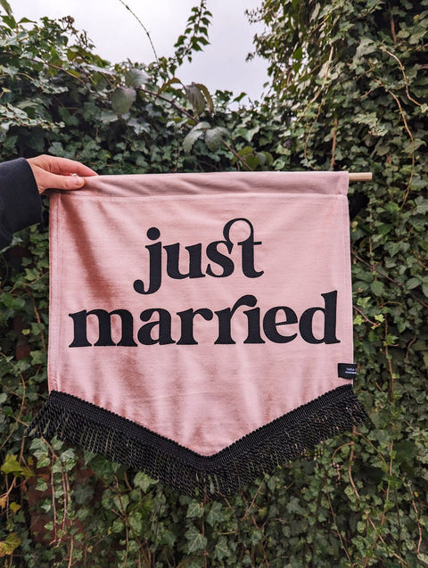 Velvet banner in dusty pink with "just married" text and black fringing.