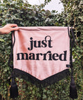 Velvet banner in dusty pink with "just married" text, black fringing and black hanging tassels