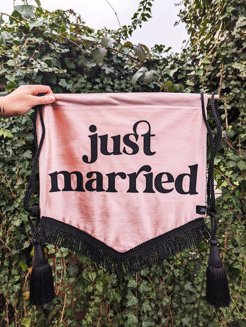 Velvet banner in dusty pink with "just married" text, black fringing and black hanging tassels