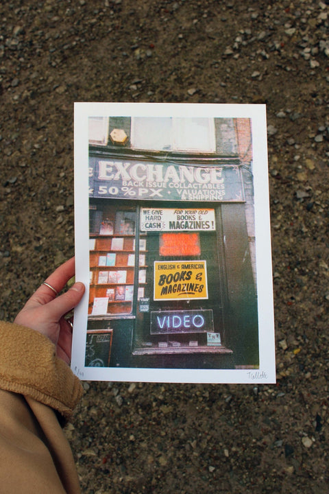 Hand holding a print of Manchester Arndale Book Exchange shop.