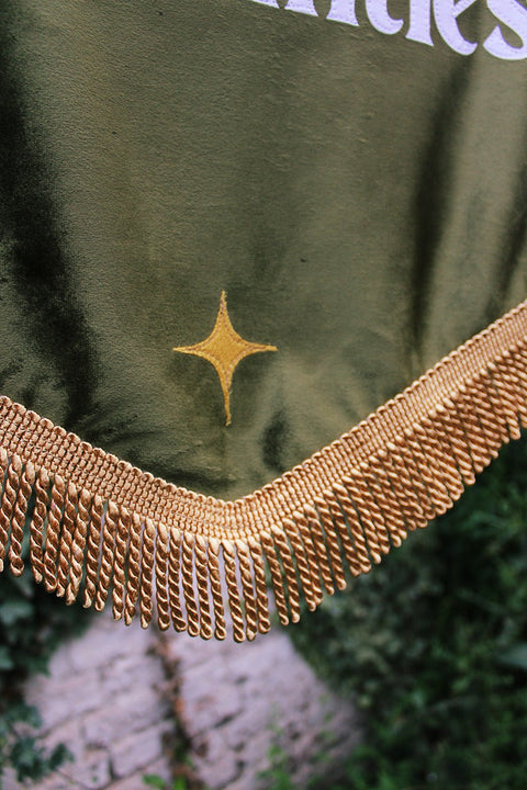 Close up of wedding banner with gold fringing and gold applique star.